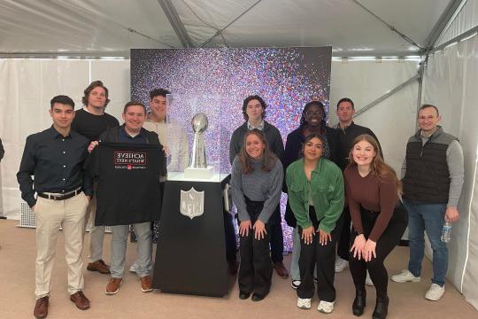 Students in The Front office with the NFL Super Bowl trophy.